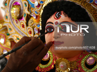 An artisan gives a final touches to an idol of the Goddess Durga ahead of the upcoming 'Durga Puja' festival in Ajmer, in the Indian state o...