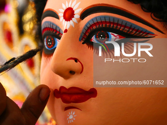 An artisan gives a final touches to an idol of the Goddess Durga ahead of the upcoming 'Durga Puja' festival in Ajmer, in the Indian state o...