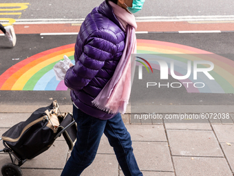 A woman in protective face mask is seen walking at Waterloo Bridge street in front of NHS reinbow as cases of Covid-19 rise during the secon...