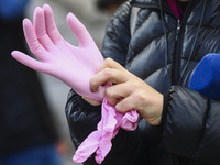 A woman puts silicon gloves on during coronavirus pandemic. Krakow, Poland on October 9th, 2020. Due to the increasing spread of COVID-19 in...