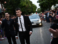 Two boys walks hand in hand during the high school graduates parade through the Bulgarian town of Svilengrad on May 26, 2015 (