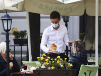 A waiter is wearing a protective face mask during coronavirus pandemic. Krakow, Poland on October 9th, 2020. Due to the increasing spread of...