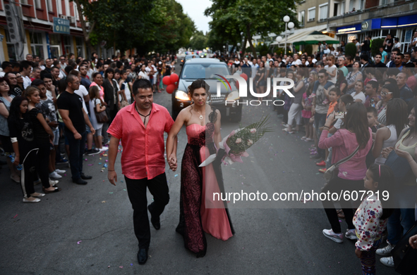 A young couple walks hand in hand during the high school graduates parade through the Bulgarian town of Svilengrad on May 26, 2015 