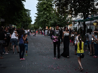 A young roma couple walks hand in hand during the high school graduates parade through the Bulgarian town of Svilengrad on May 26, 2015 (