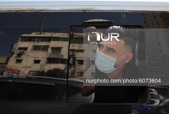 A Palestinian man wearing a face mask looks out a car window amid the coronavirus disease (COVID-19) outbreak,in Gaza City, on October 10, 2...