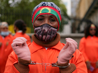 Activists in prison jumpsuits and handcuffs protest human rights abuses against the Oromo people of Ethiopia at a demonstration opposite Dow...