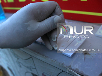 A health worker in personal protective equipment (PPE) collects a nasal swab samples from homeless people for Covid-19 Rapid Antigen Testing...