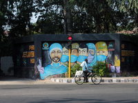 A cyclist passes by a mural honouring frontline workers against coronavirus, at R K Puram, on October 10, 2020, in New Delhi, India.  (
