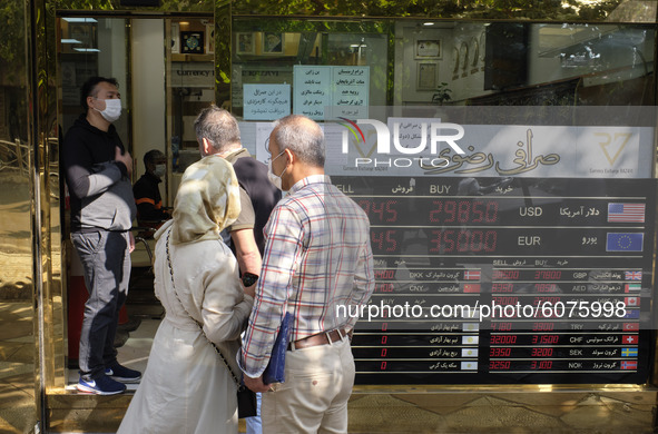 An Iranian couple stand out of a currency exchange shop as they wait to buy U.S. Dollar in Tehran’s business district on October 10, 2020. U...
