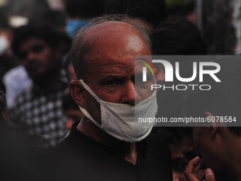An indian shiite muslim wearing a protective mask as a protective measure against Covid 19 corona virus,mourns during a religious procesion...