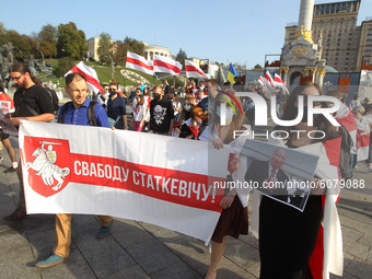 People hold historical white-red-white flags of Belarus during a rally of solidarity with Belarusian protests on Independence Square in Kyiv...