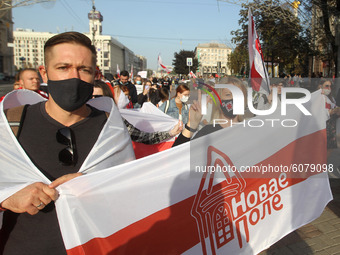 People carry historical white-red-white flags of Belarus during a rally of solidarity with Belarusian protests on Independence Square in Kyi...
