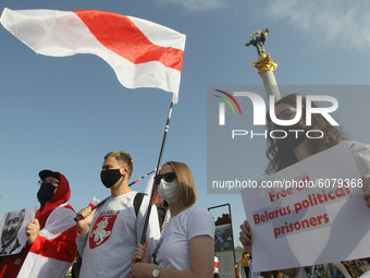 People hold historical white-red-white flags of Belarus during a rally of solidarity with Belarusian protests on Independence Square in Kyiv...