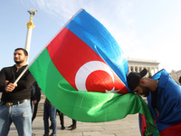 An Azerbaijani man bows before Azerbaijan's flag during a rally in support of Azerbaijan against Armenia in the Nagorno-Karabakh conflict on...