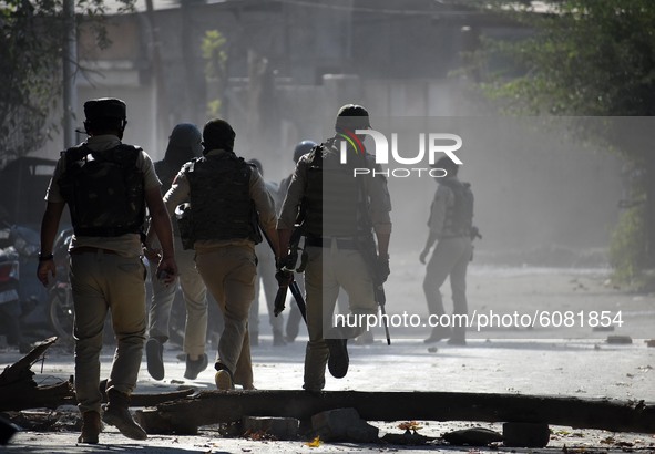 Indian policemen chase away protesters near the gun-battle site in Barzulla area of Srinagar, Kashmir on October 12, 2020.Clashes erupted be...