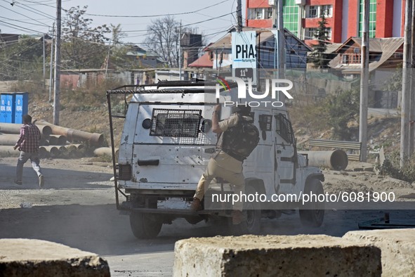 A police vehicle chasing a protestor in Barzulla area of Srinagar, Kashmir on October 12, 2020.Clashes erupted between angry protestors and...
