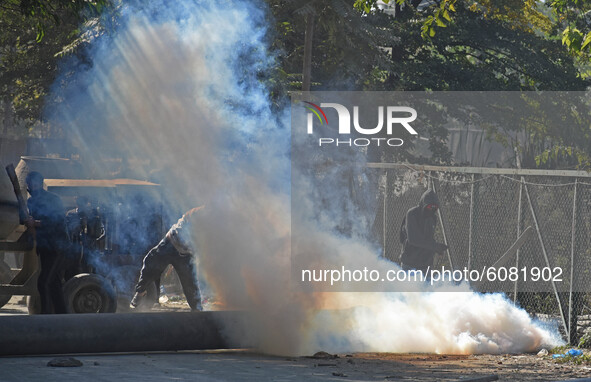A protester reacts after Indian police fired tear smoke canisters near the gun-battle site in Barzulla area of Srinagar, Kashmir on October...