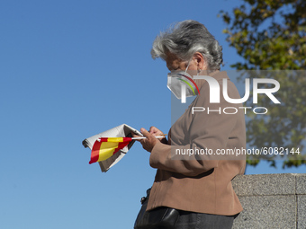 A group of people with flags of Spain attend the during the event organized on the occasion of the National Holiday Day, in Madrid this Mond...