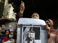 Demonstrators, wearing protective face masks, hold pictures of hunger-striking Palestinian prisoner Maher Al-Akhras, who is held by Israel,...