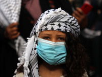 A Palestinian girl, wearing a protective face mask, during a rally to show solidarity with hunger-striking Palestinian prisoner Maher Al-Akh...