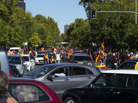 Demonstrators hold a constitutional Spanish flag  next to an in-vehicle protest against the Spanish government on Spain's National Day durin...