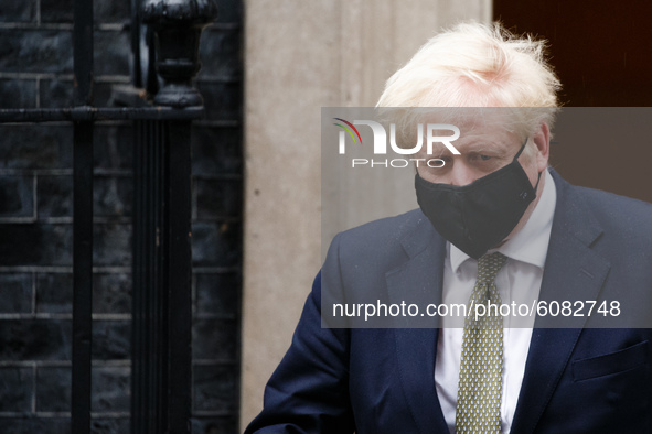 British Prime Minister Boris Johnson wears a face mask as he leaves 10 Downing Street headed for the Houses of Parliament in London, England...