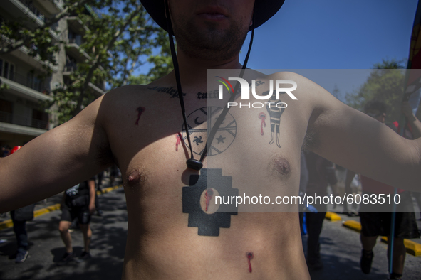 A person has simbology tattoos of the Mapuche people-nation, and native people  during a protest in the framework of the Day of the Race, in...