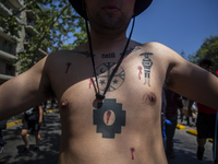 A person has simbology tattoos of the Mapuche people-nation, and native people  during a protest in the framework of the Day of the Race, in...