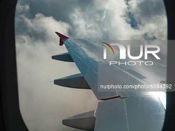 Wing view from the window of the plane with clouds during the flight. Flying with Lauda Airbus A320 airplane with registration 9H-LMJ during...
