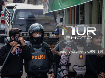 Riot police officers detain protesters who caused unrest during a rally to protest against the Omnibus Law in Magelang, Central Java, Indone...