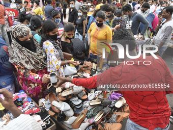 People shop from a road side shoe stall without maiintaining social distancing amid coronavirus emergency in Kolkata, India, 13 October, 202...
