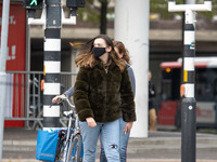 Daily life in Eindhoven city in the Netherlands with people wearing facemask as they are outside walking or on the bicycle as a protective m...