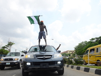 Youth of ENDSARS protesters display the Nigerian flag on top a car showing his support to the ongoing protest against the harassment, killin...