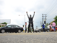 Youth of ENDSARS protesters raise his fists in the air on his bicycle in support of the ongoing protest against the harassment, killings and...