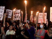 Female activists and students take part in a torch procession demanding women's safety and justice for rape victims, amid the coronavirus di...