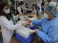 Medical personnel at a health kiosk installed in Colonia Lomas Estrella, Iztapalapa, receive means for the application of free tests for det...