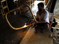 A man is burning rattan to make a chair in Palembang, Indonesia on October 14, 2020. (