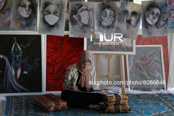 Palestinian artist Kholoud al-Desouki,27, paints during lockdown at home in Khan Yunis in the southern Gaza Strip, amid strict restrictions...
