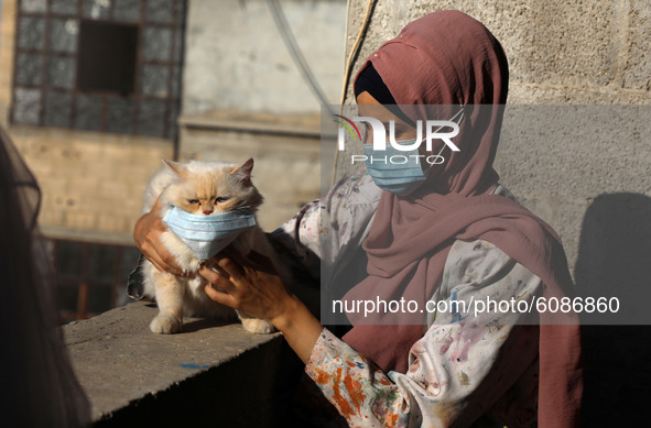 Palestinian artist Kholoud al-Desouki,27, pets a cat during lockdown at home in Khan Yunis in the southern Gaza Strip, on October 12, 2020,...