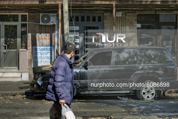 A man looks a destroyed car by an Azerbaijan rocket in the streets of  Stepanakert on October 13, 2020. 