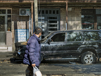 A man looks a destroyed car by an Azerbaijan rocket in the streets of  Stepanakert on October 13, 2020. (
