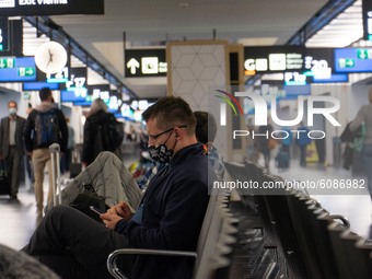 Passengers wearing facemasks, face shields, gloves and other safety measures are seen in the airport terminal, at the F Gates area of Vienna...
