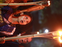 Students and activists take part in a torch-lit march during an ongoing protest against an alleged gang-rape and brutally torturing of a wom...