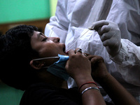 A health worker in personal protective equipment (PPE) collects a nasal swab sample from sports athletes for Covid-19 Rapid Antigen Testing...