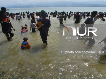 
A number of residents wet their bodies with sea water while participating in the Safar bathing ritual on Tumbelaka Beach, Palu City, Centr...