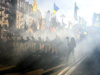 Veterans, activists and supporters of Ukraine's nationalist movements light flares during a procession to mark the Defender of Ukraine Day a...