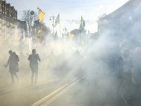 Veterans, activists and supporters of Ukraine's nationalist movements light flares during a procession to mark the Defender of Ukraine Day a...