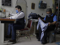 Armando Ontiveros and José García, tailors, working on some garments in their business located in El Vergel, Iztapalapa, Mexico City, after...