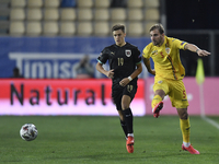 Mihai Balasa of Romania in action against Christoph Baumgartner of Austria during match against Romania of UEFA Nations League football matc...