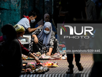A vendor wearing a face mask tends to her shoe products at a sidewalk in Manila, Philippines on October 15, 2020.(